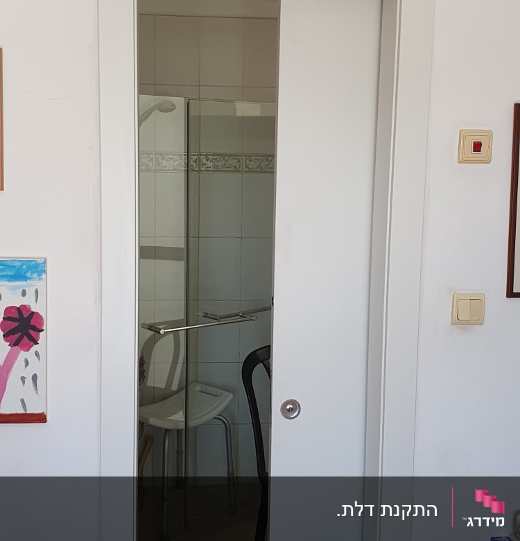 דלת הזזה לבנה פתוחה חלקית לחדר אמבטיה